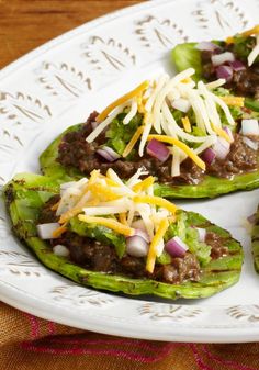 three stuffed peppers on a white plate with cheese