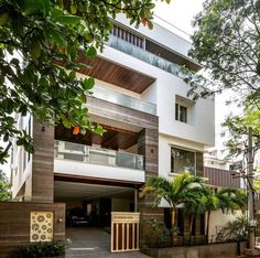 an apartment building with trees and plants around it's entrance area, in the daytime