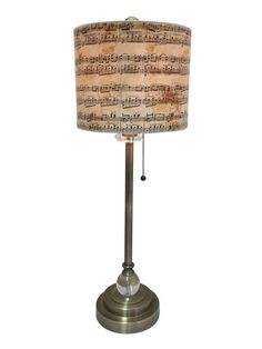 a lamp that is on top of a metal stand with musical notes printed on it