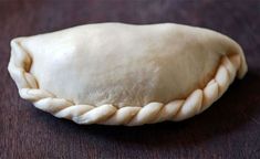 an uncooked pastry sitting on top of a wooden table