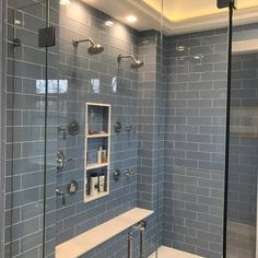 a walk in shower sitting next to a white bath tub under a sky blue tiled wall