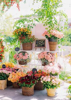 many different types of flowers in baskets on a table