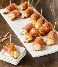 bacon wrapped appetizers are served on white plates