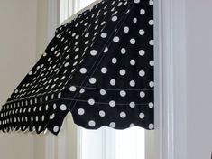 a black and white polka dot curtain hanging from a window