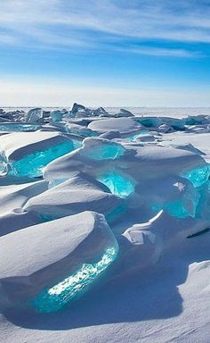 ice formations in the snow with bright blue water flowing from one end to the other