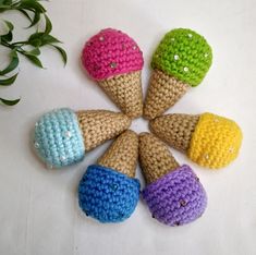 six crocheted ice cream cones are arranged in a circle on a white surface