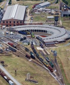 an aerial view of a train yard with trains on tracks and buildings in the background