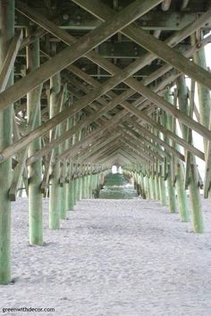 the underside of a wooden pier with many poles