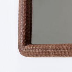 a wooden frame mirror hanging on the wall