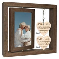 an anniversary photo frame with two hearts hanging from the front, and a key chain attached to it