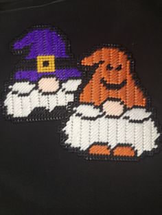 two embroidered patches on the back of a black jacket with an orange and white dog wearing a witch hat