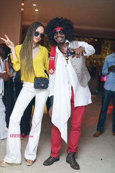 two people dressed in white and yellow posing for the camera with one person wearing sunglasses