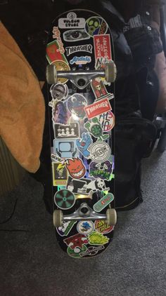 a skateboard with lots of stickers on it's back end and bottom part