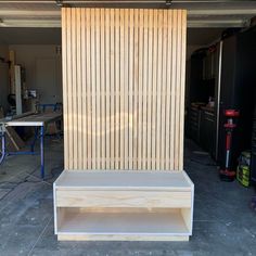 a wooden bench sitting in front of a garage door with shelves on the outside side