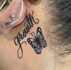 a woman's behind the ear tattoo that says strength and a butterfly on it