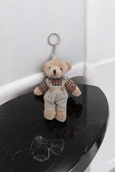 a teddy bear sitting on top of a black table