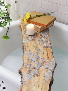 a candle is sitting on top of a log in the bathtub next to a book