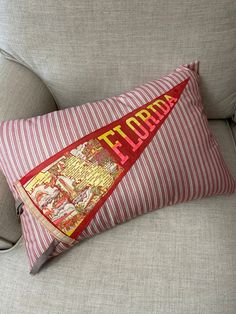 a red and white striped pillow sitting on top of a couch