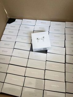 the box is full of white boxes with ear buds on them and there are many other packages in it