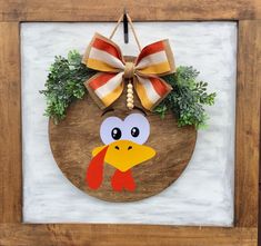 a turkey with a bow hanging on a wooden plaque in front of a white brick wall