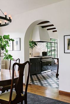 a dining room table with chairs and a potted plant in the middle of it