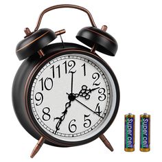 an alarm clock with two batteries next to it