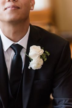 a man wearing a suit and tie with a flower in his lapel pin on his lapel