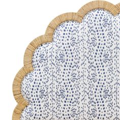 a blue and white cloud shaped cushion on top of a wooden frame with wicker trim