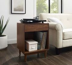 a living room with a couch, coffee table and record player on top of it