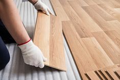 a person laying on top of a wooden floor next to a piece of plywood