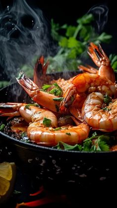 cooked shrimp in a skillet with garnishes and lemon wedges