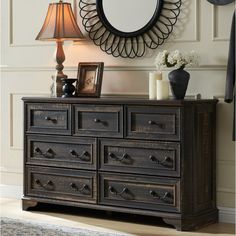 a dresser with drawers and a mirror on the wall