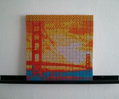 a piece of art made out of legos is displayed on a shelf above a wall