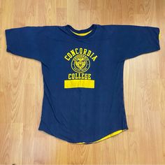 Vintage Concordia College Portland, Or Logo Double Face T-Shirt Rare Size Medium. Navy Blue And Yellow, Double Face T-Shirt. Concordia College Portland, Oregon Crest Logo In Yellow On Front. Sign Of Use Includes Cracking In Logo As Shown In Photo. Made In Usa. Size Tags Says Large. Likely Fits Men’s Medium Best. Measurements Below. Armpit To Armpit: 19.5 Inches Length: 27 Inches Retro Blue T-shirt For College, Vintage Embroidered Logo Sweatshirt For College, Vintage T-shirt With Lettering For College, Vintage College Sweatshirt With Logo Print, Vintage Long Sleeve College T-shirt, Oregon College, Crest Logo, Vintage Shirts, Mens Fitness