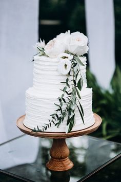 a wedding cake with white flowers and greenery