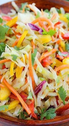 a wooden bowl filled with coleslaw salad and garnished with cilantro