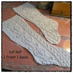 two white knitted socks sitting on top of a table