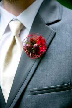 a man wearing a suit and tie with a boutonniere on his lapel