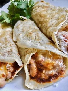 three quesadillas on a plate with cilantro garnishes