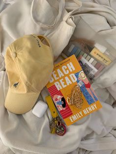 a hat, book and other items are laying on a bed