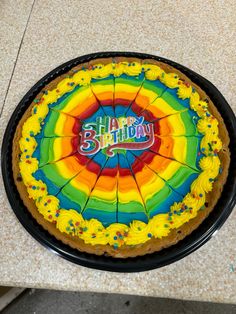 a birthday cake decorated with rainbow icing and the words happy birthday written on it