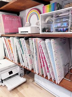 the shelves are filled with many different types of binders and paper, including an inkjet