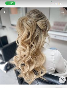 the back of a woman's head with long blonde hair in a half - up braid