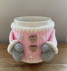 a knitted cup cozying with two teddy bears on the front and one in the back