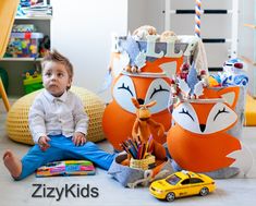 a baby sitting on the floor next to toys