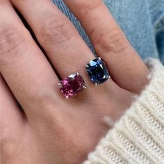 two different colored stone rings on someone's hand