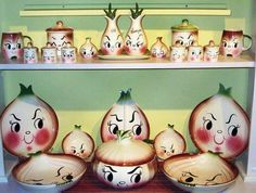 an assortment of onion heads with faces painted on them in front of a shelf filled with other items