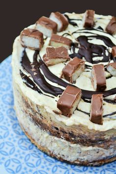 there is a cake with chocolate and cream frosting on the top, sitting on a blue plate