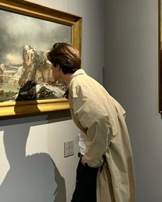 a man looking at a painting in a museum