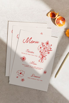 two menu cards with orange slices on the table